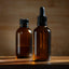 PHOTO OF TWO BROWN DROPPER BOTTLES SITTING ON A TABLE WITH A BLURRED BACKGROUND